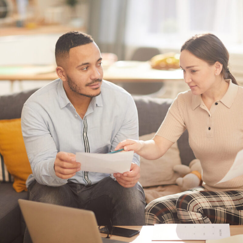 Modern Family Paying Taxes Portrait of adult couple doing paperwork while paying taxes online in sunlit home interior, copy space